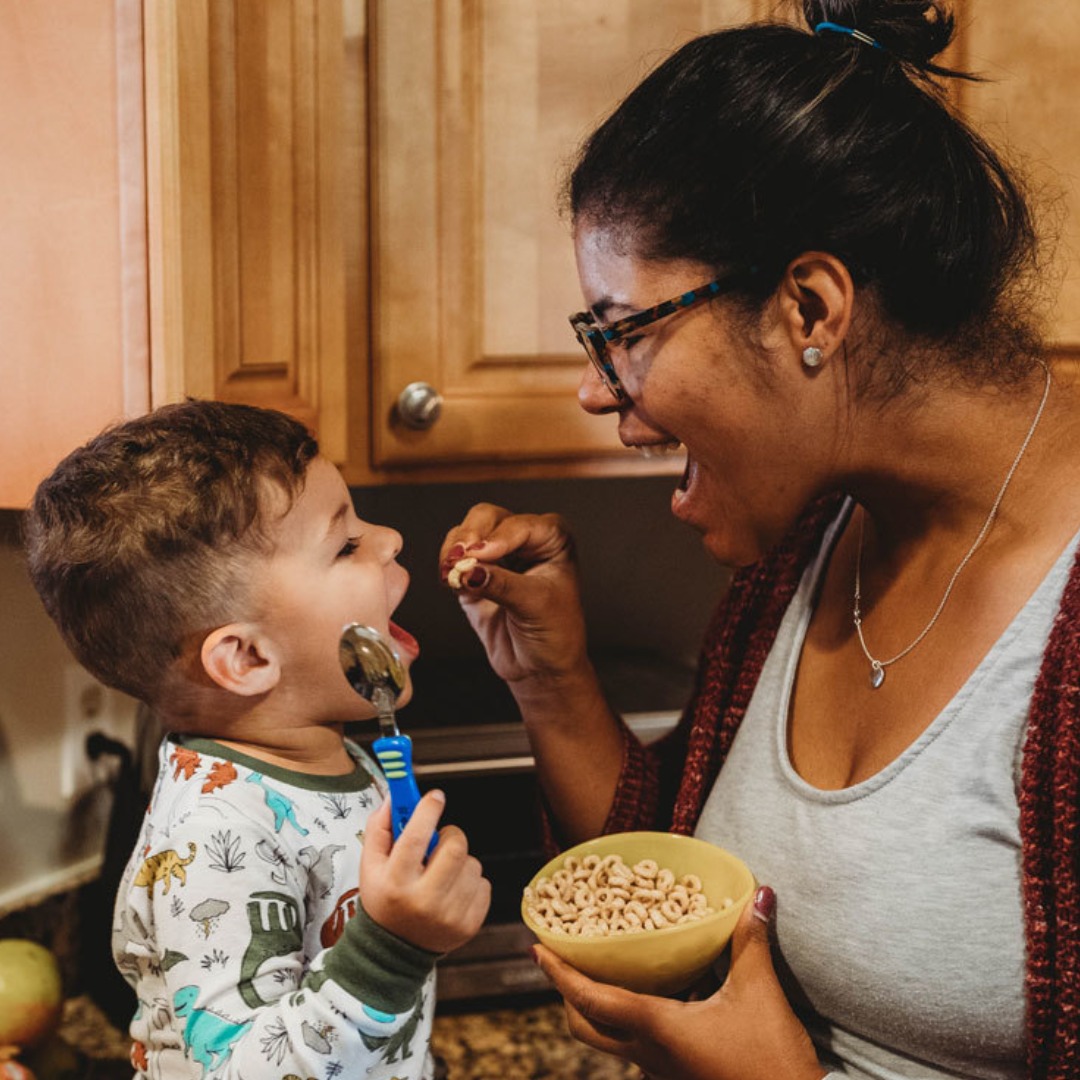 Mom feeding son Cheerios